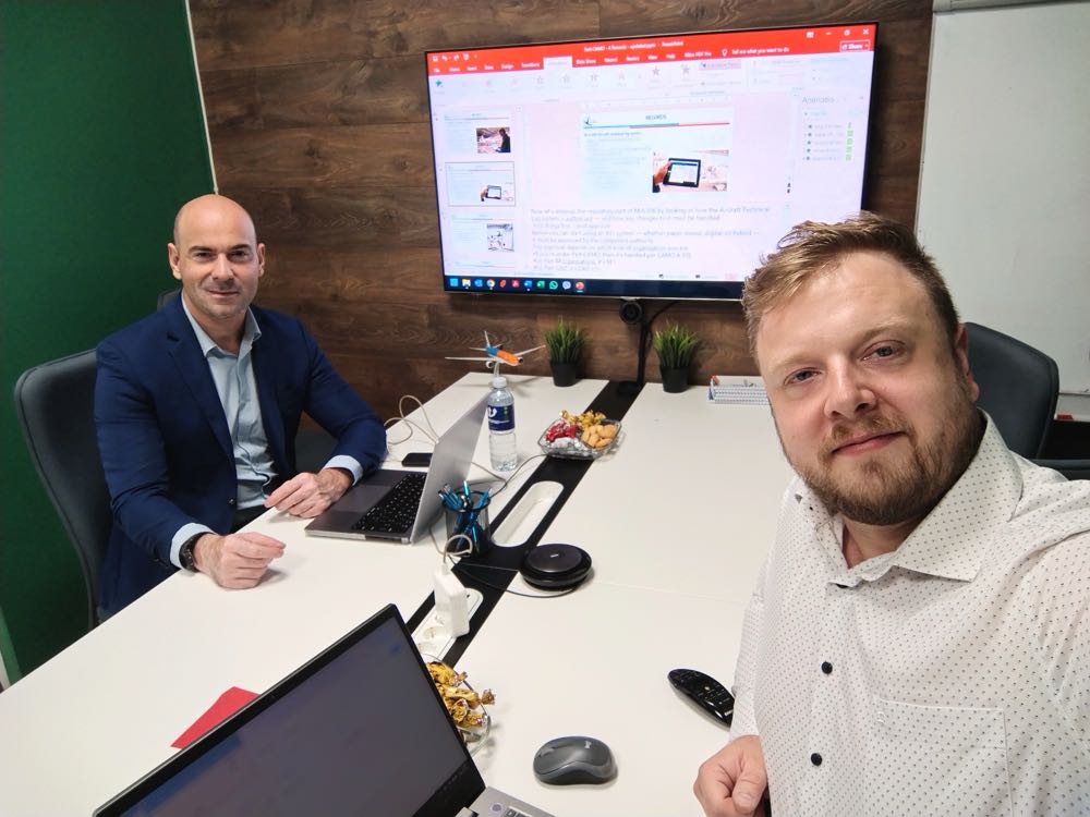 Two Vendura trainers at a meeting table with Part-CAMO course material on screen